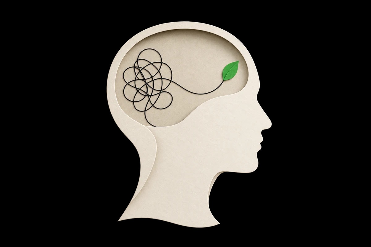 A paper head with tangled thoughts unwinding into a green leaf.